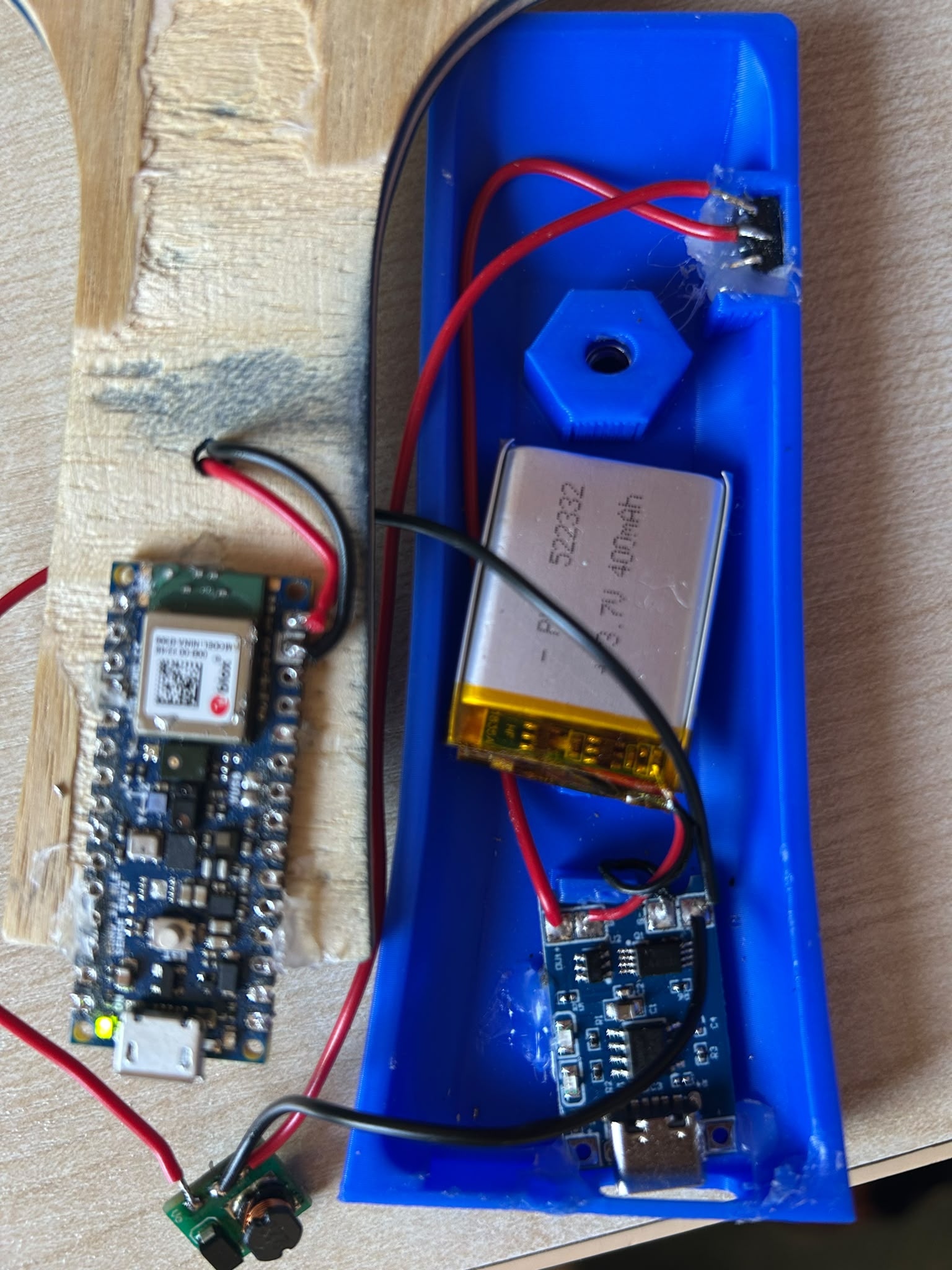 Internal electronics of the smart table tennis racket, including the microcontroller, battery, charger, and boost converter